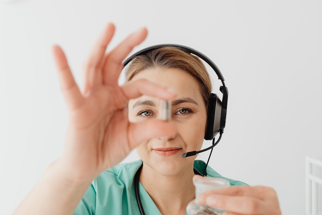 who-we-are Female doctor in headset holding pill during online medical consultation, emphasizing telehealth.